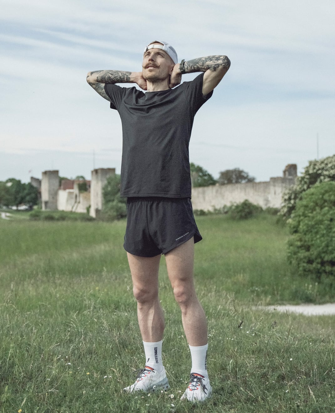 Coachis standing in nature holding his head a looking uo to the sky.